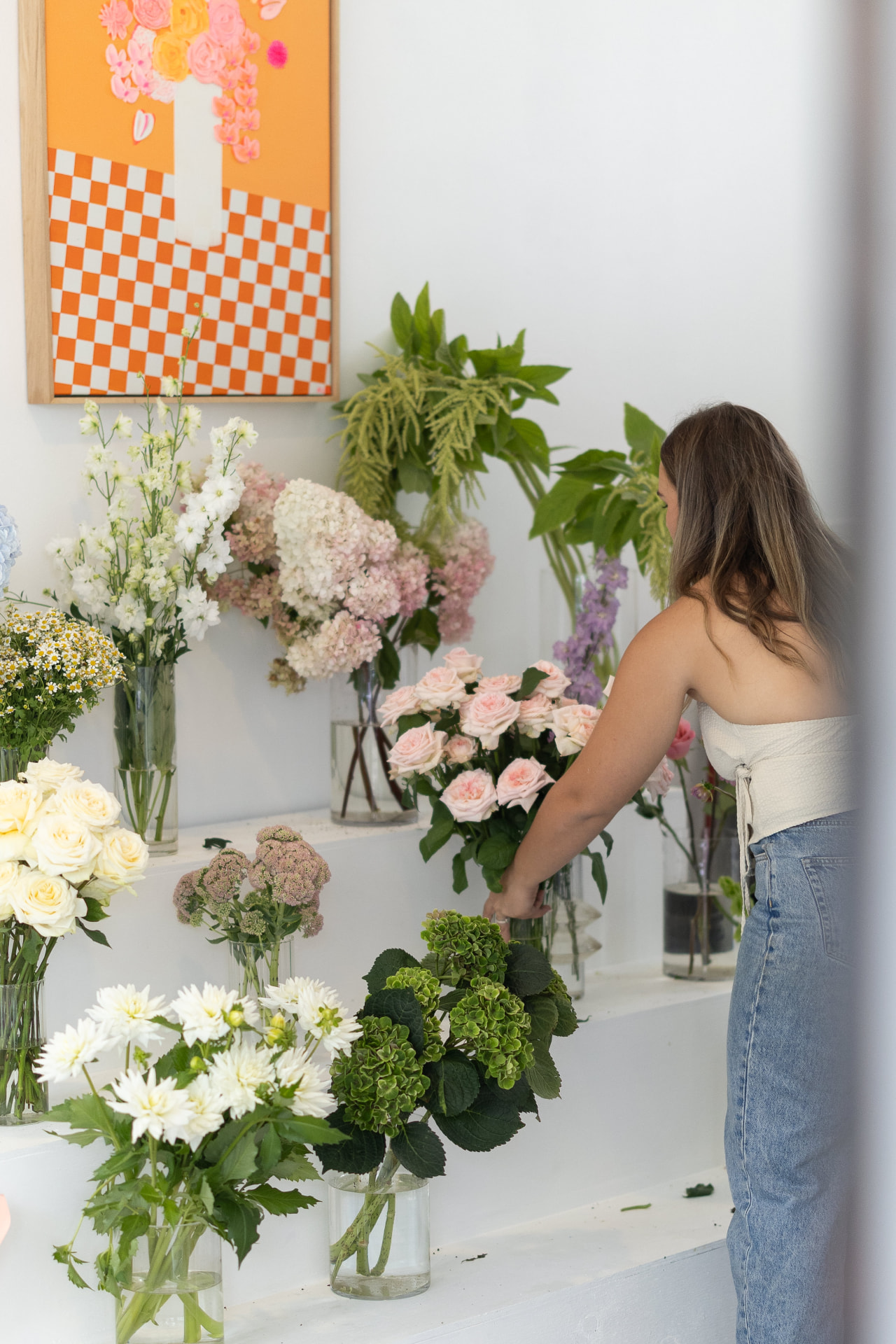 Elly arranging fresh bouquets on the display wall of the Bloom Bar