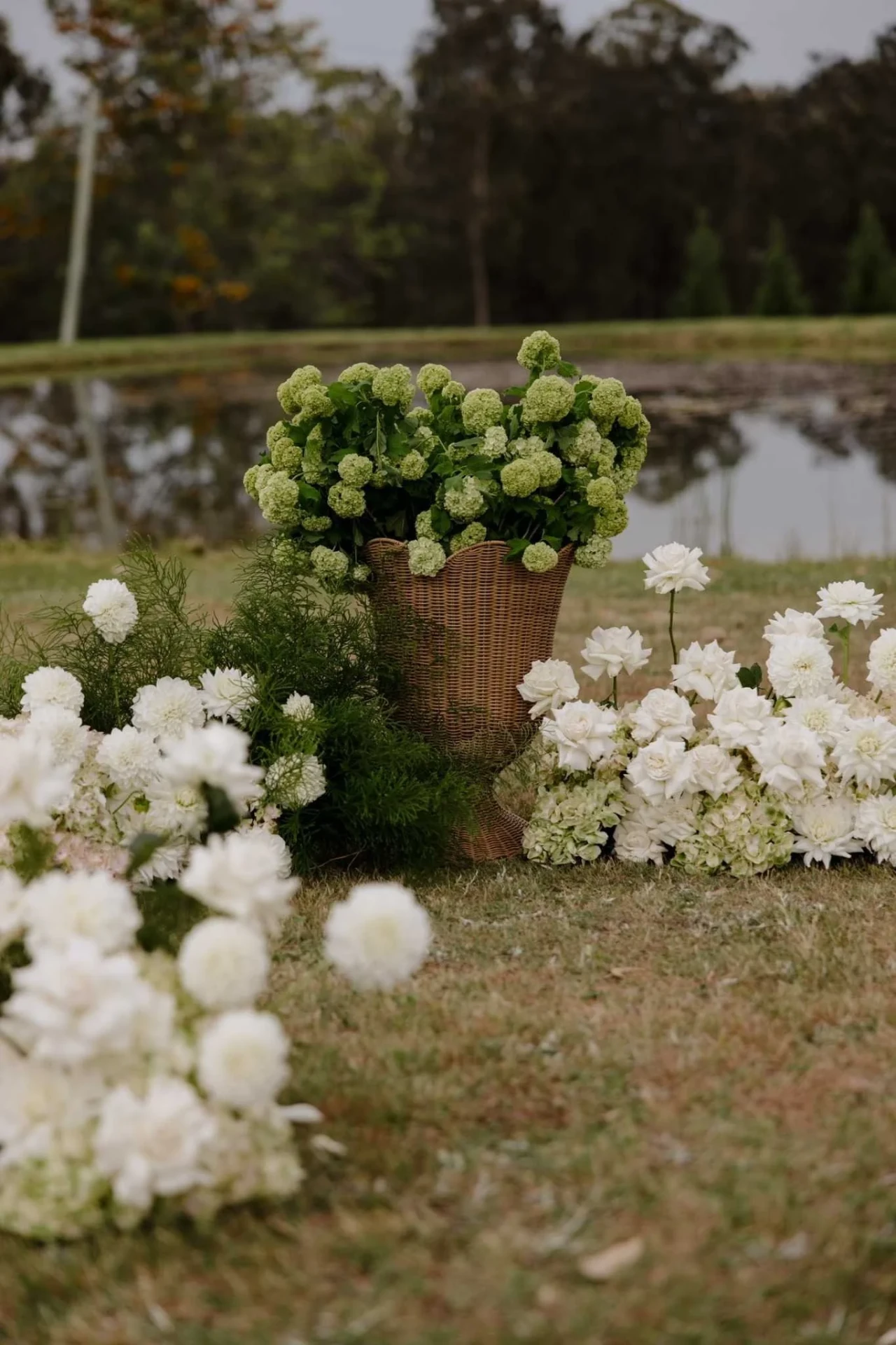 Green hydrangea basket arrangement styled beside the water