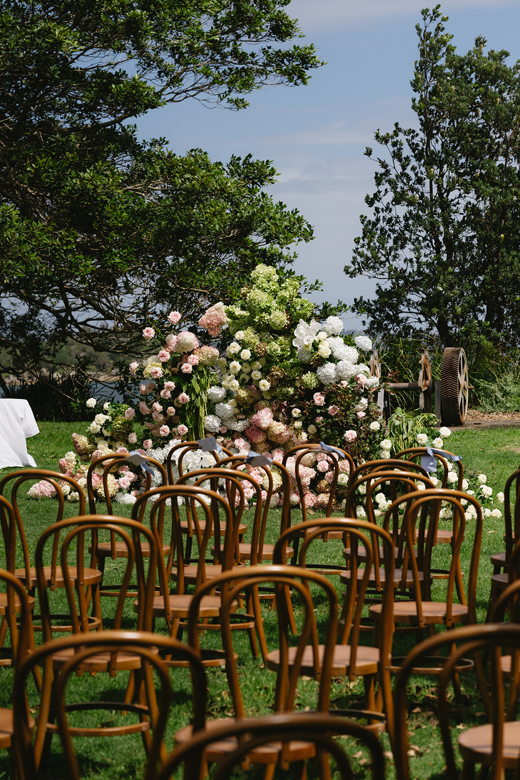 A garden meadow of pink and white hydrangeas, roses and amaranthus at the head of the wedding ceremony aisle